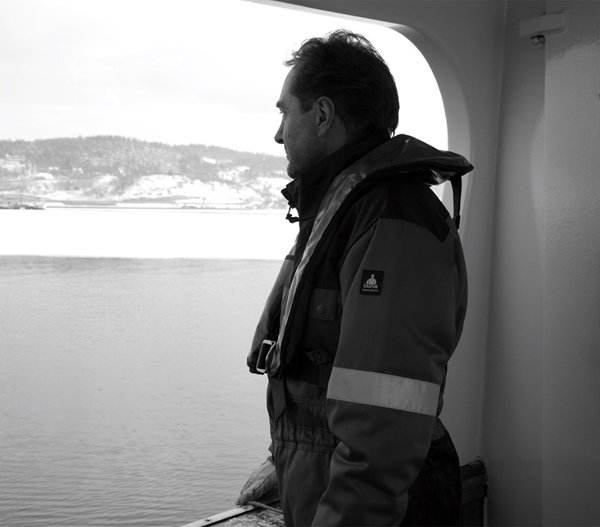Kjell Inge Rokke standing on a boat looking out at the ocean
